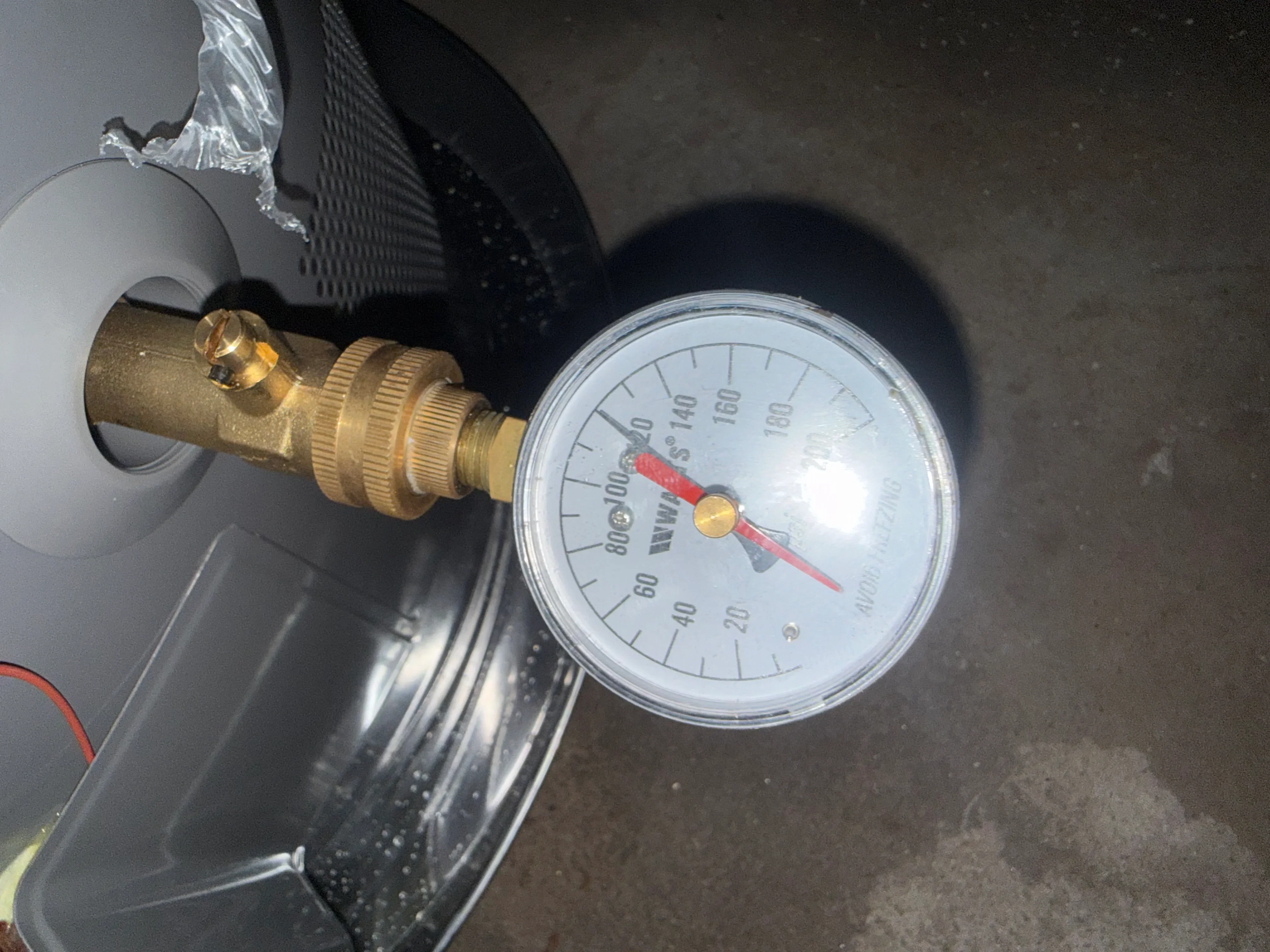 Brass pressure relief valve and gauge installed on water heater system
