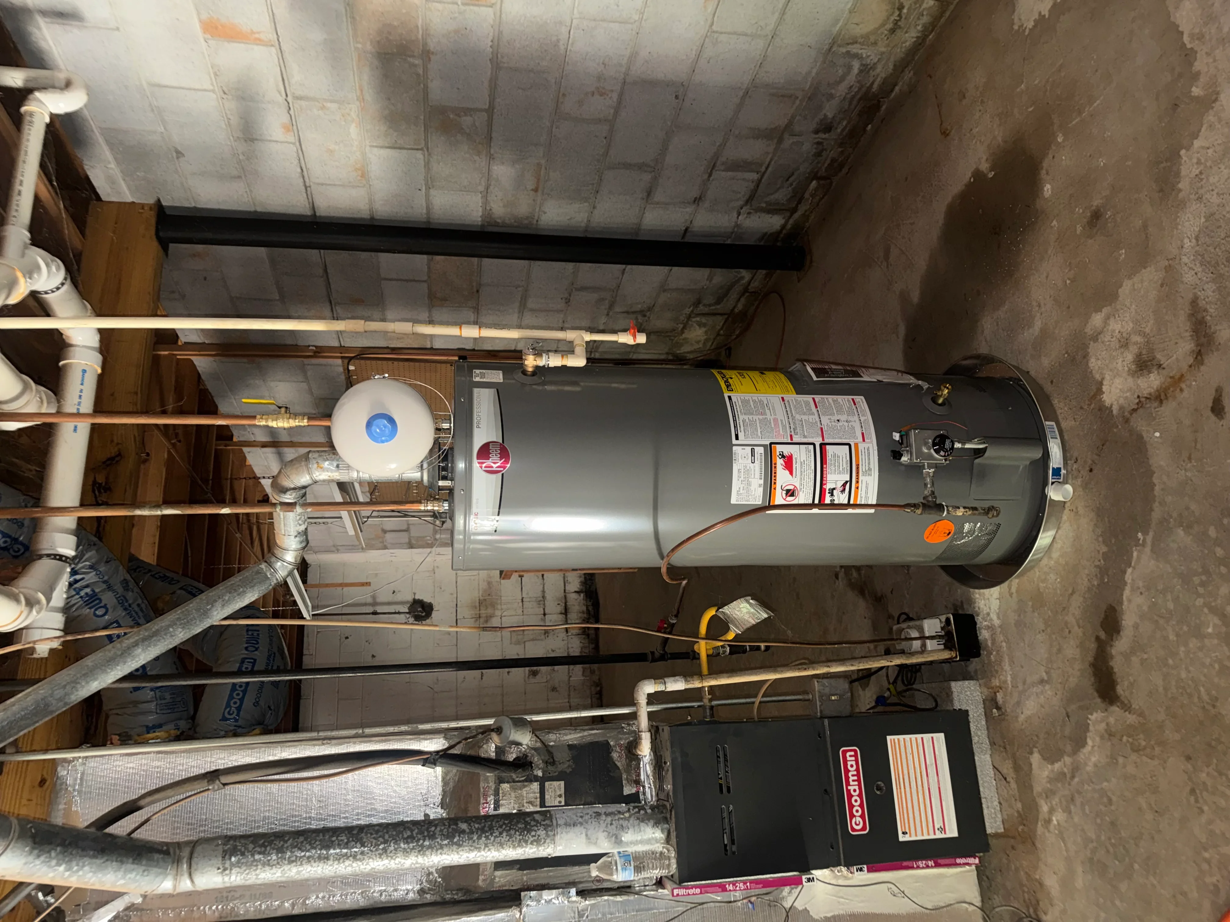 Installed residential water heater with copper piping and safety connections in utility room